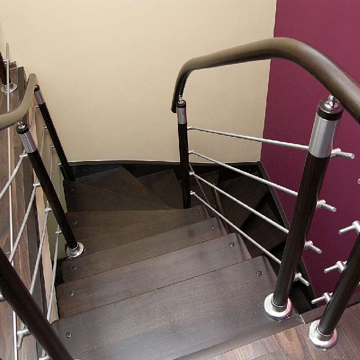 schody policzkowe wykonane z drewna bukowego barwione na ciemny brąz balustrady z elementami wykonanymi ze sali nierdzewnej